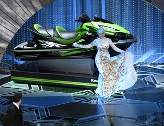 هلن میرن مقابل جت‌اسکی ایستاده و جیمی کیمل او را تماشا می‌کند. این جت‌اسکی جایزه برنده‌ای بود که کمتر از همه حرف بزند